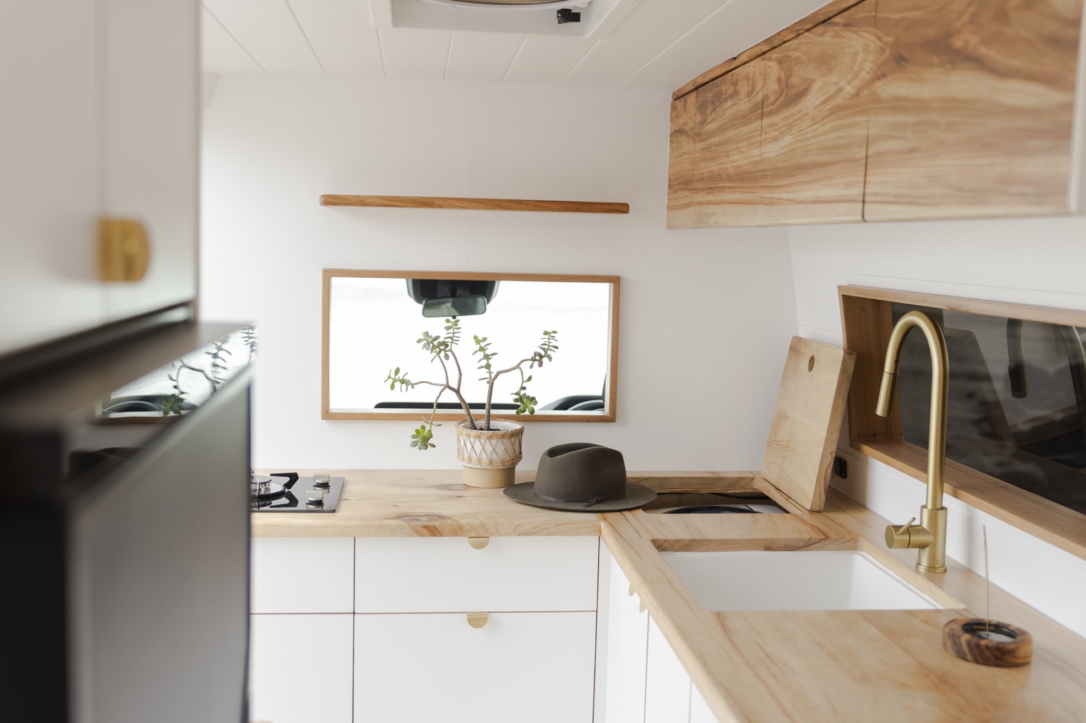 Brass tap and blonde timber kitchen inside Daisy